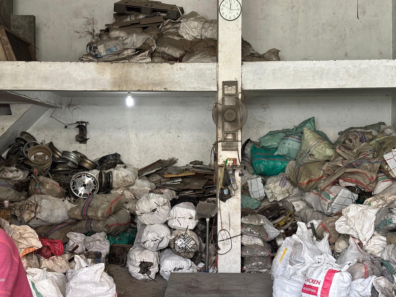 Velg dan berbagai logam bekas tersortir rapi di rak gudang